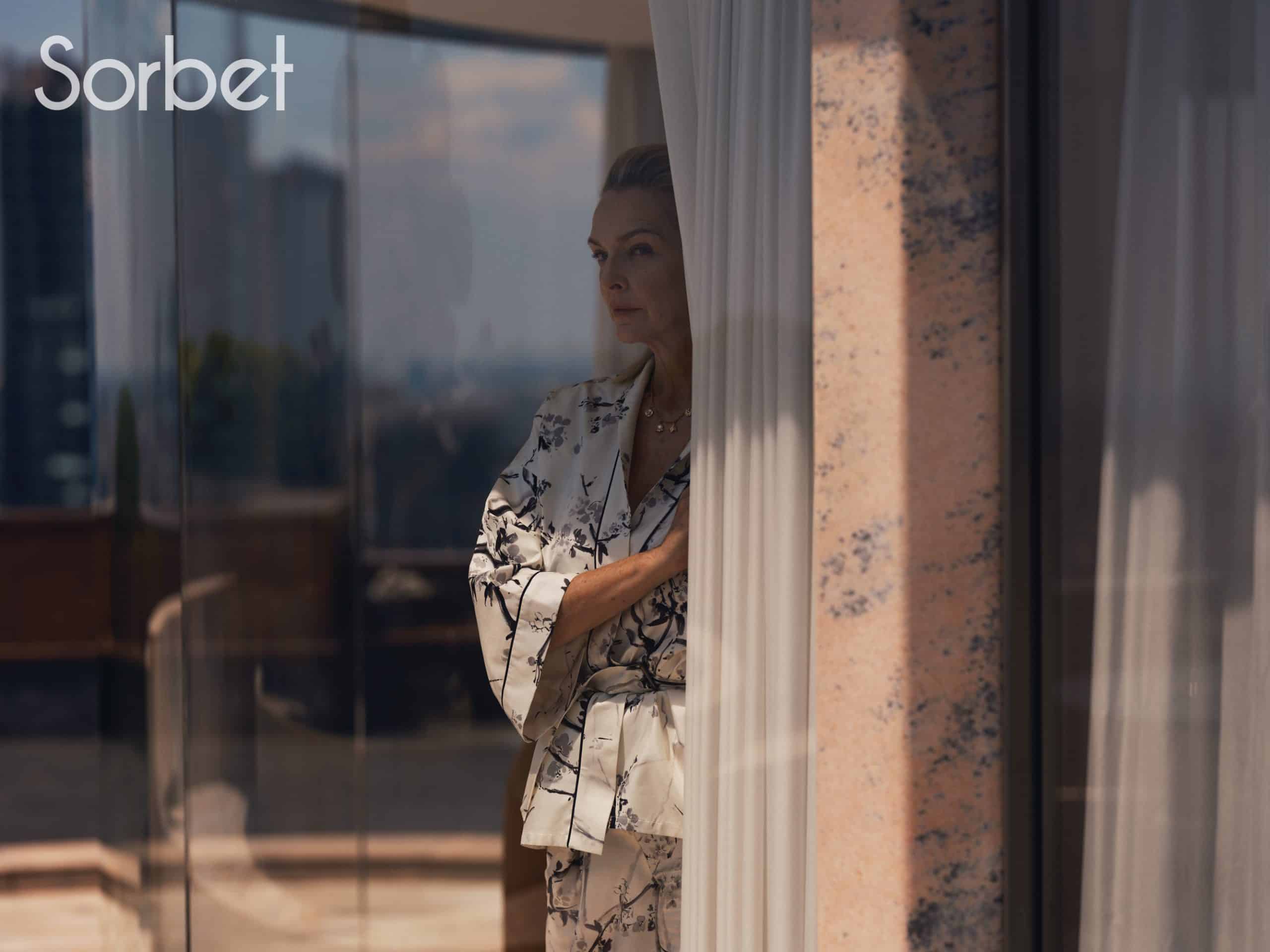 woman looking through a window in Milan wearing Dior jewelry and Dior clothes
