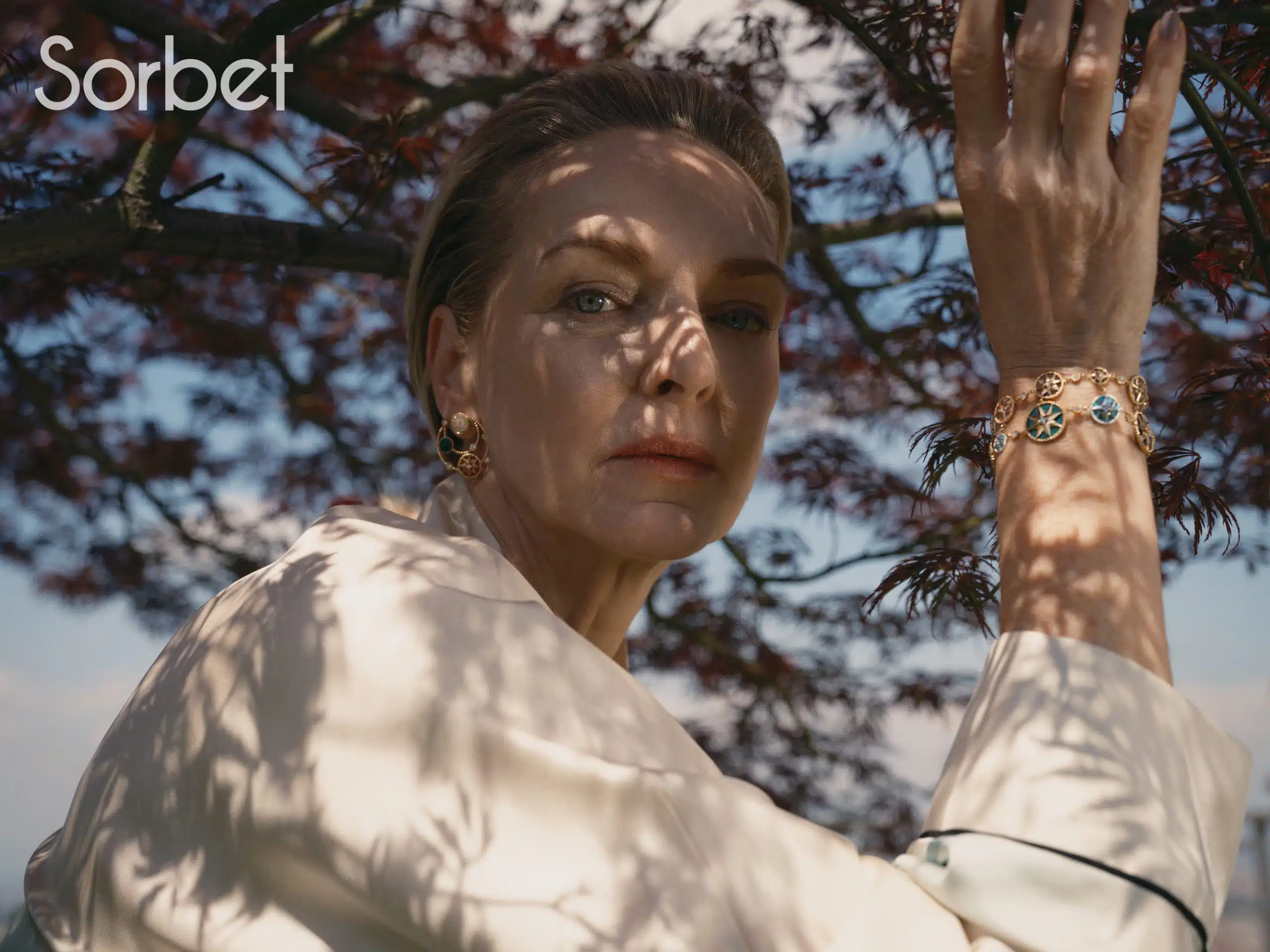 woman standing under a tree in Milan wearing Dior jewelry and Dior clothes