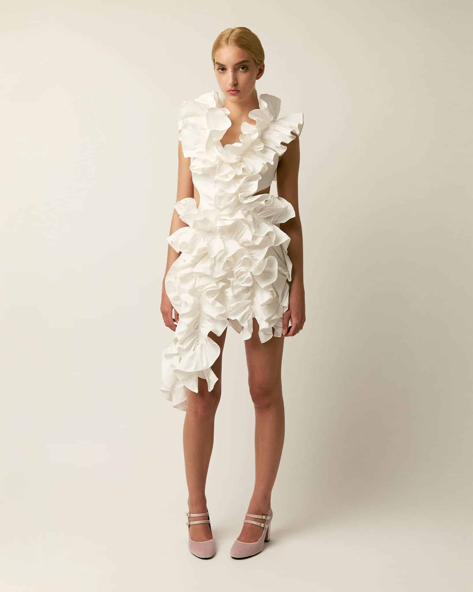 Female model wearing The Olive Dress by Aknvas in white with ruffles