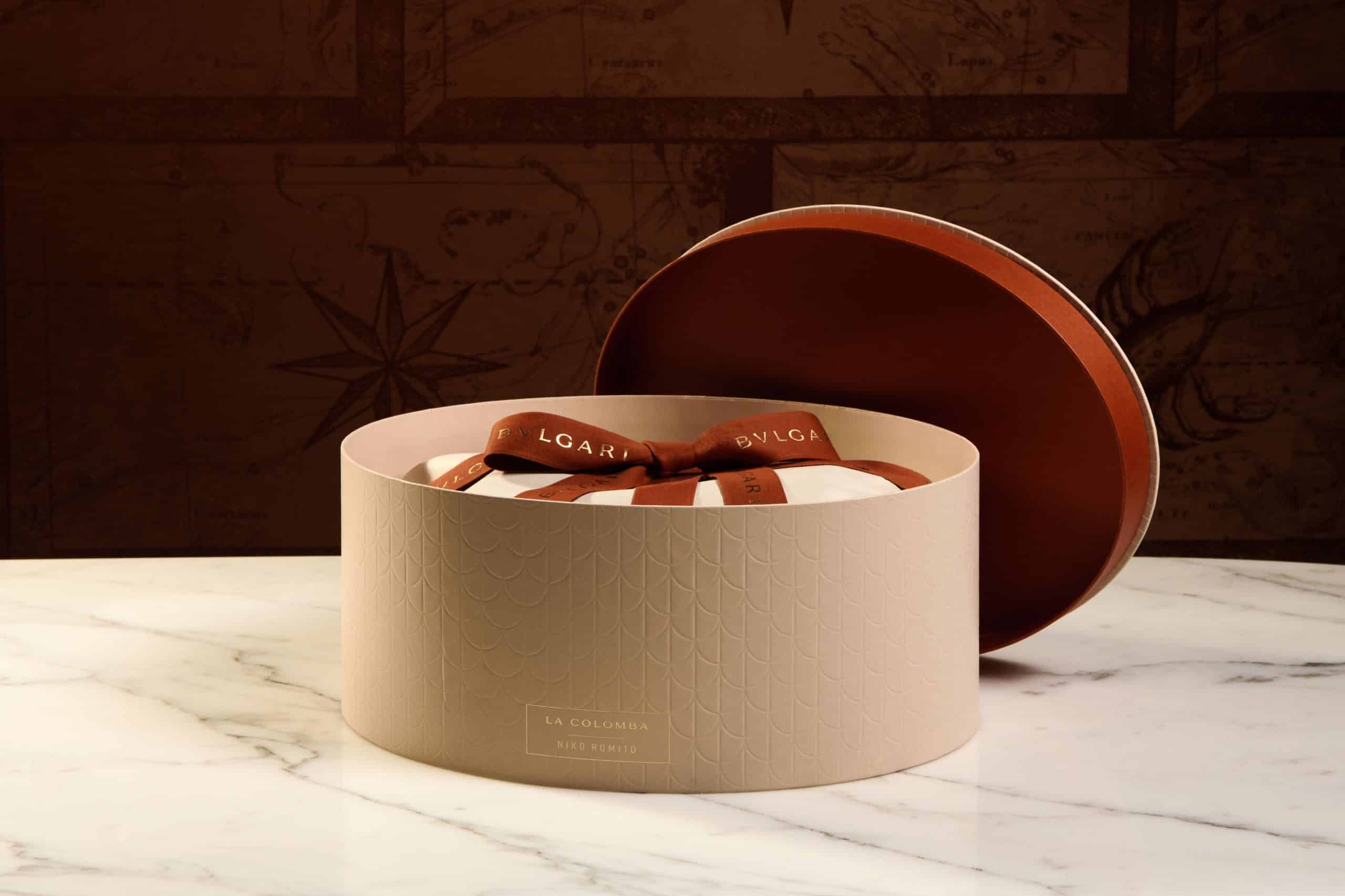 Bulgari Easter 2026 Niko Romito La Colomba cake in round luxury cream and orange branded packaging on marble.