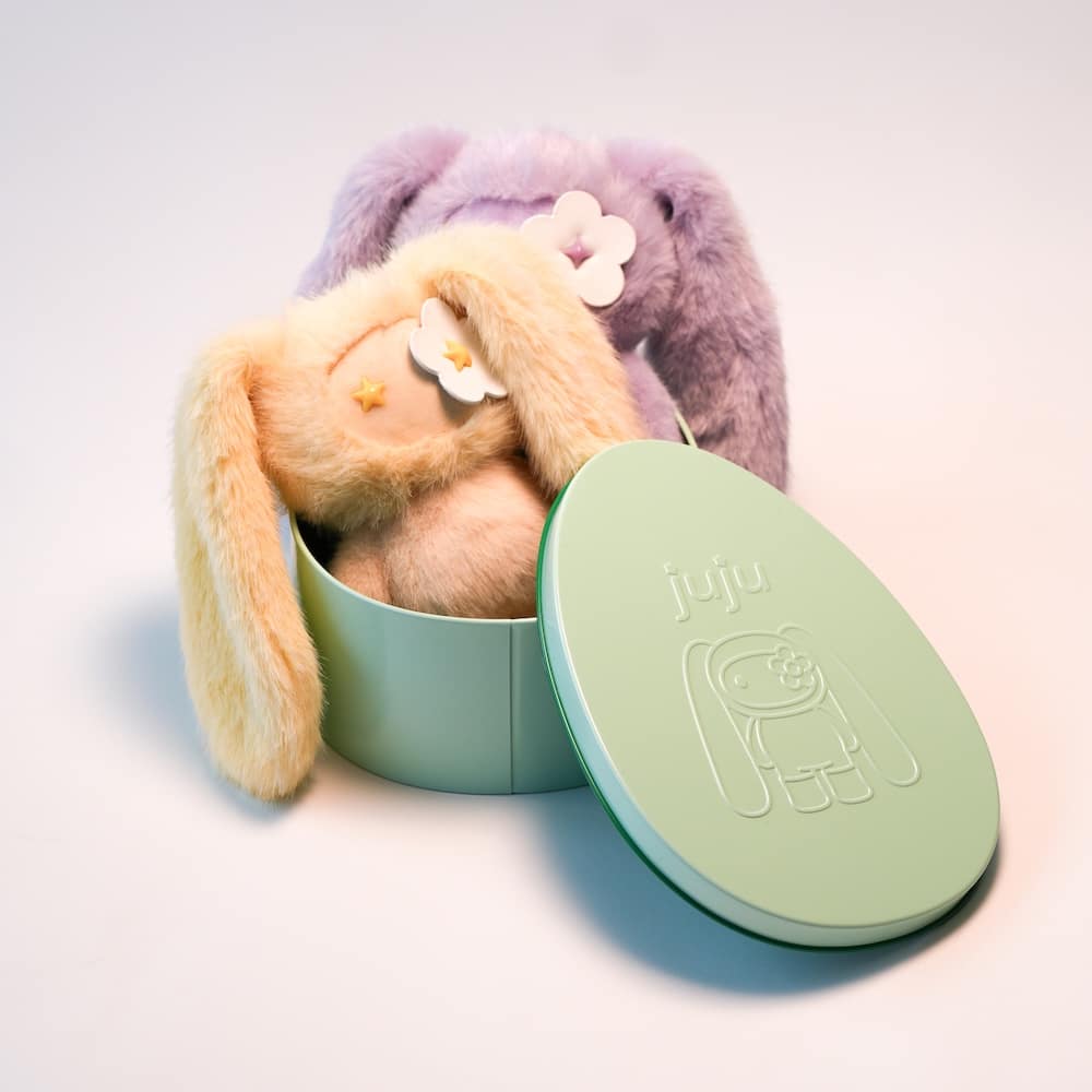 Yellow and purple stuffed animal bunnies by Hendry's Juju placed in a green easter egg shaped box