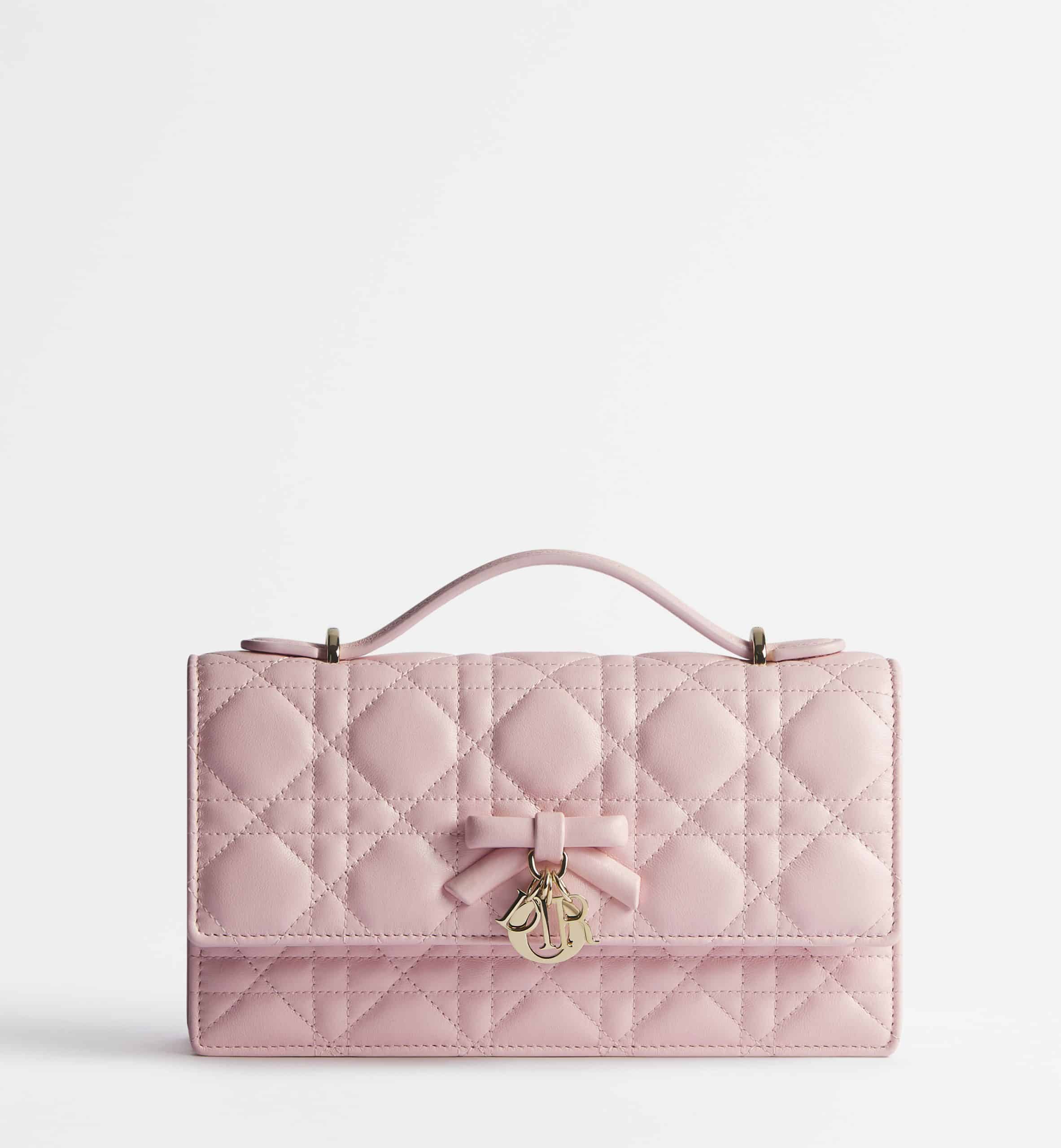 Dior My Dior Mini Bag Rose Soupir Cannage lambskin in baby pink topped with a baby pink bow and Dior charm in gold against a white background