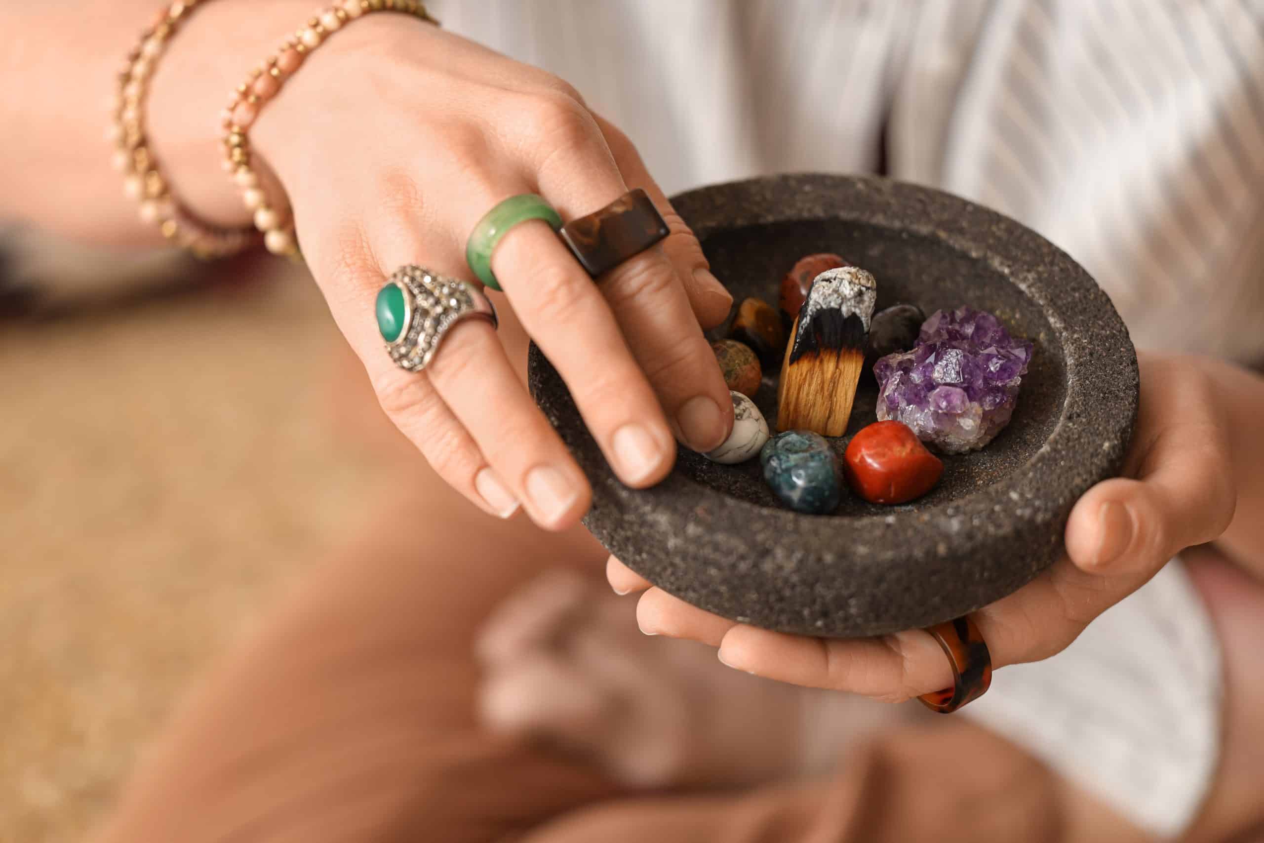 Woman meditating with different stones, closeup